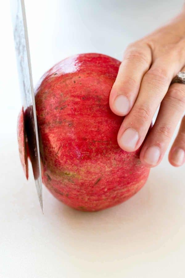 用刀切下石榴的顶和底。