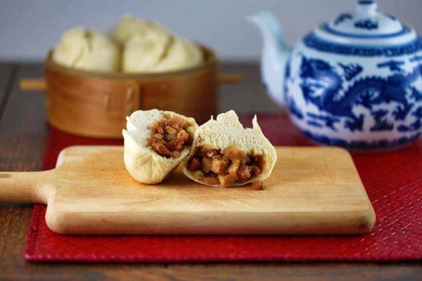 叉烧包放在砧板上切成两半,显示里面的馅料