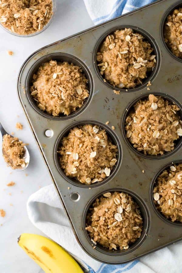 一个松饼烘烤锡充满了香蕉块和老式卷燕麦,为烤箱准备。