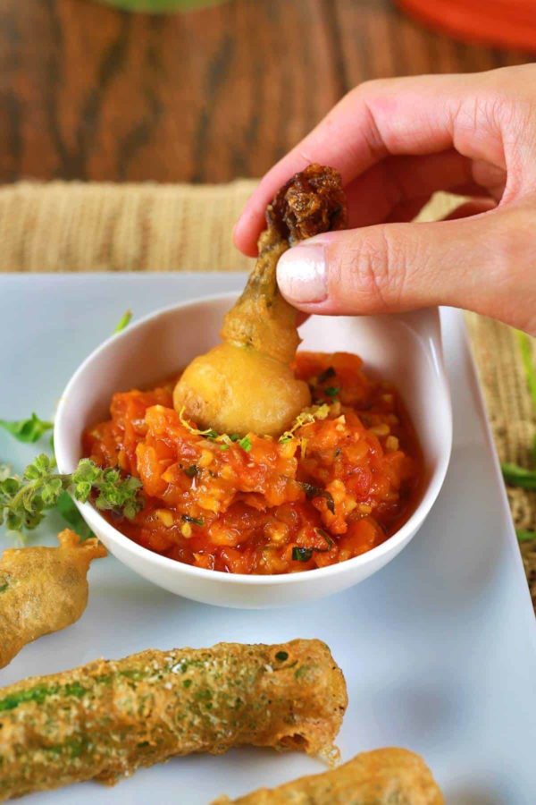 把炸南瓜花浸入一碗番茄酱里