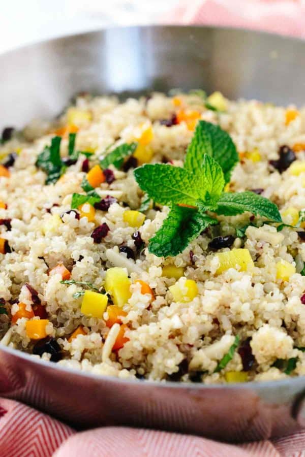 蔓越莓杏仁奎奴亚藜在一个平底锅里用薄荷叶装饰