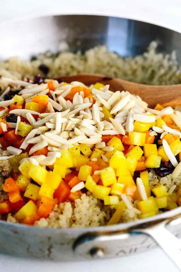 木匙子混合切碎的坚果,胡椒和蔓越桔在平底锅里