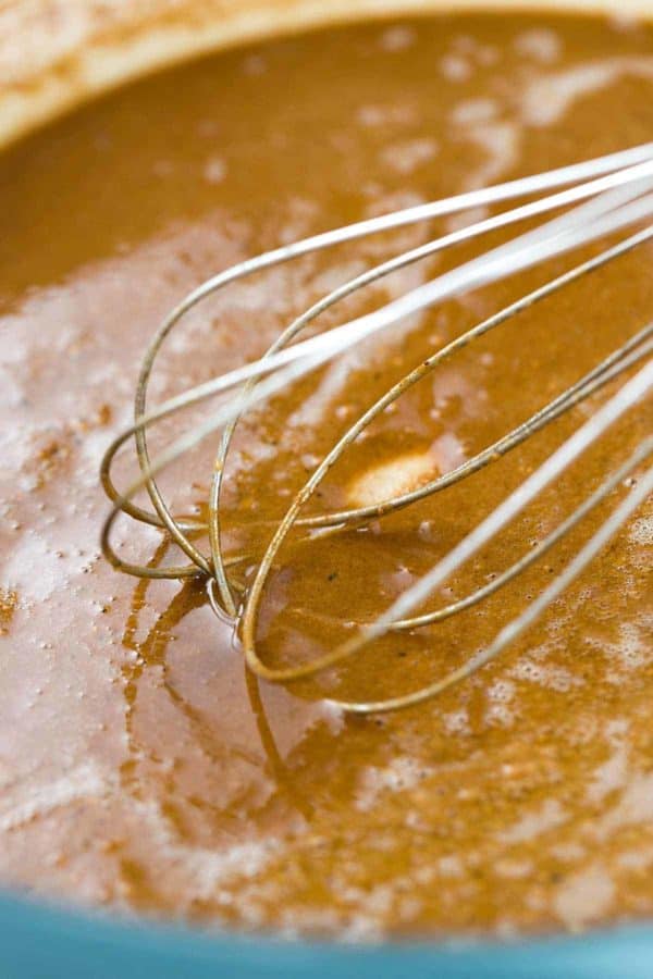 一个打蛋器在一个大锅里搅拌秋葵汤的特写照片