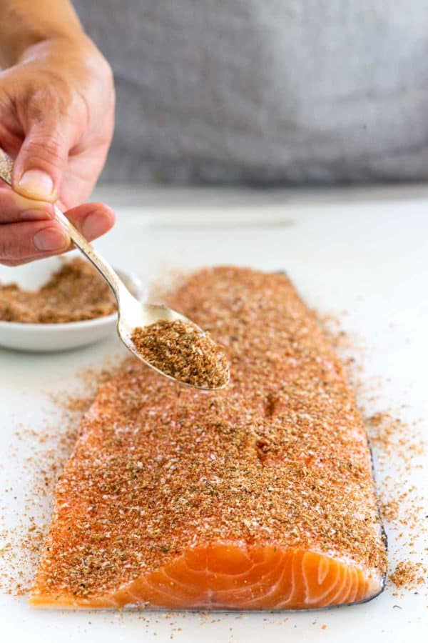 在鲑鱼片上撒上一勺香料