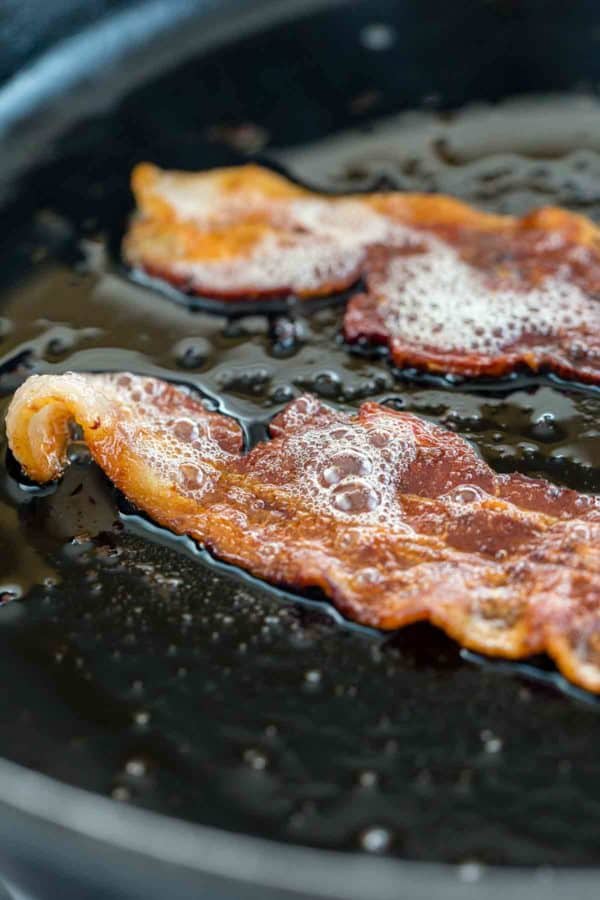 在平底锅上烤培根时发出咝咝声