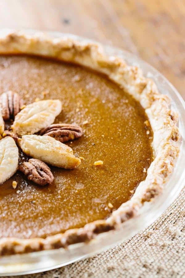 在一个清楚的盘的南瓜饼用叶子和核桃在上面