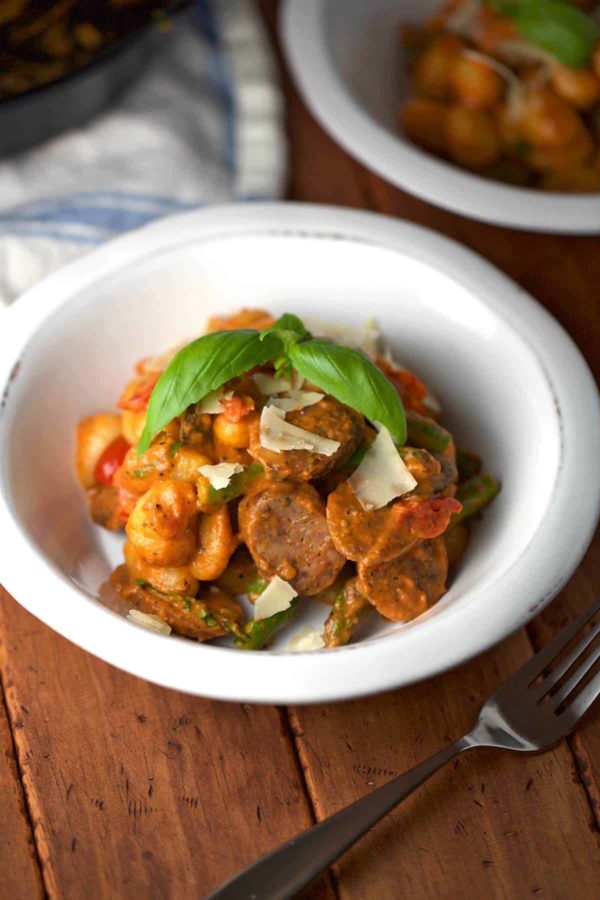 一碗白色的土豆团子和几片番茄酱鸡肉香肠