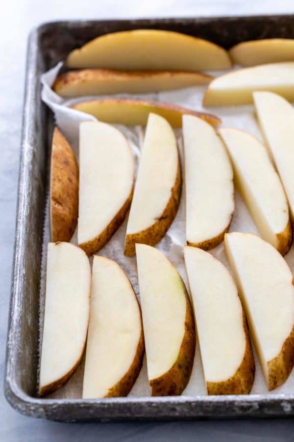 切片赤褐色土豆干燥在纸毛巾衬里的板料盘