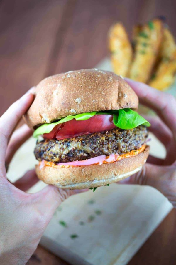 拿着素食汉堡的两只手