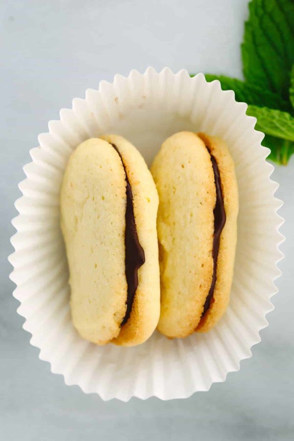 一个白色纸杯蛋糕包装里装着两块米兰甜饼