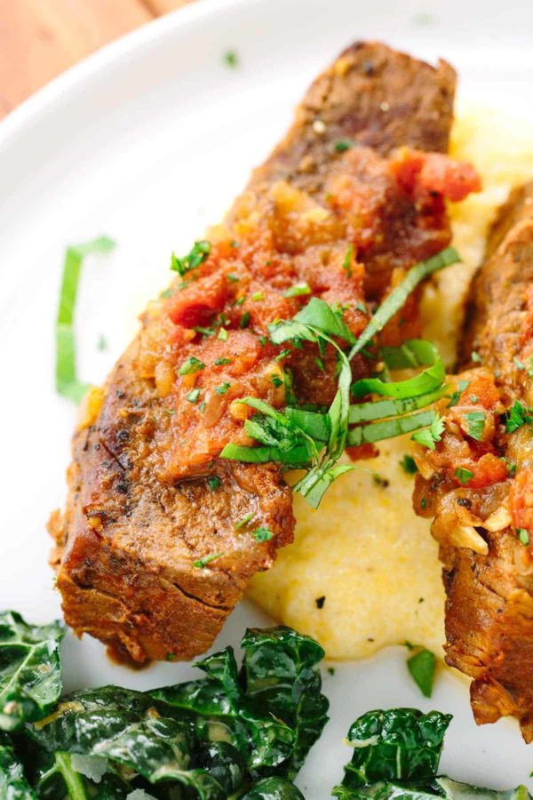 在板材的短肋骨用西红柿酱和装饰