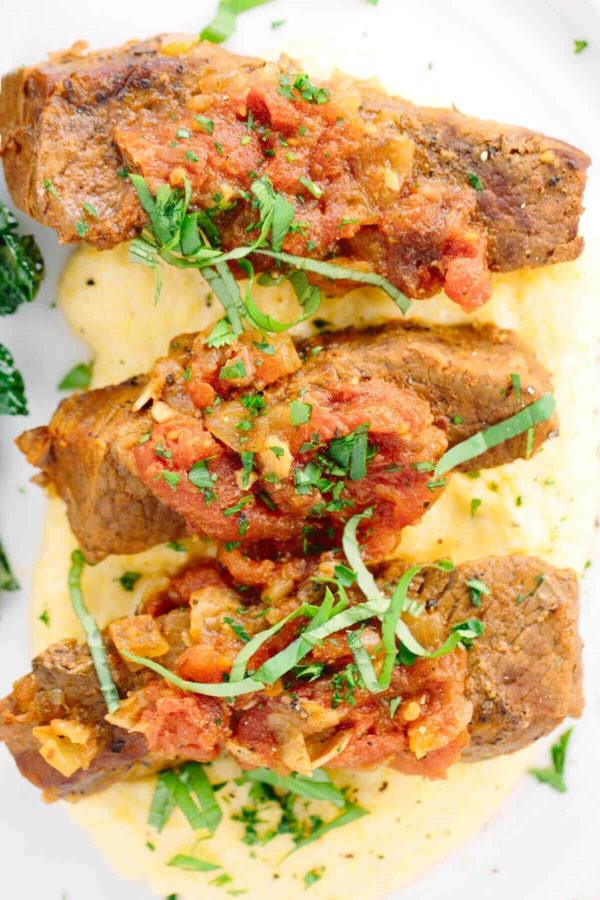 在一块板材的三个牛肉短肋骨与玉米粥