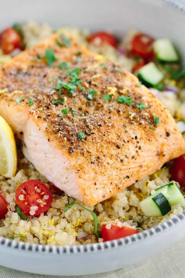 三文鱼内圆角用放置在有蔬菜和奎奴亚藜的一个碗的干燥季节