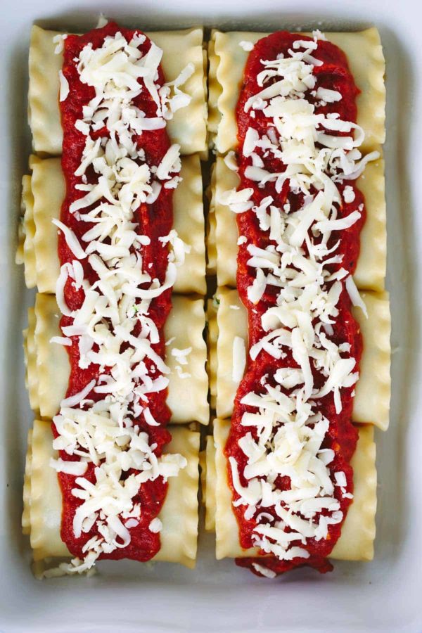 烤盘充满烤宽面条卷起,配上番茄酱和切碎的马苏里拉奶酪