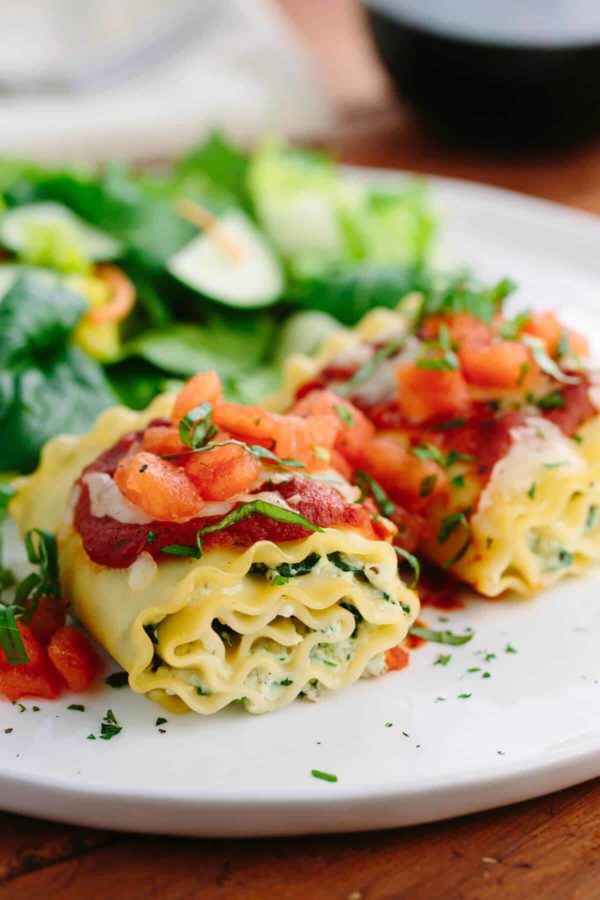 烤宽面条卷放在盘子上,上面浇上番茄酱