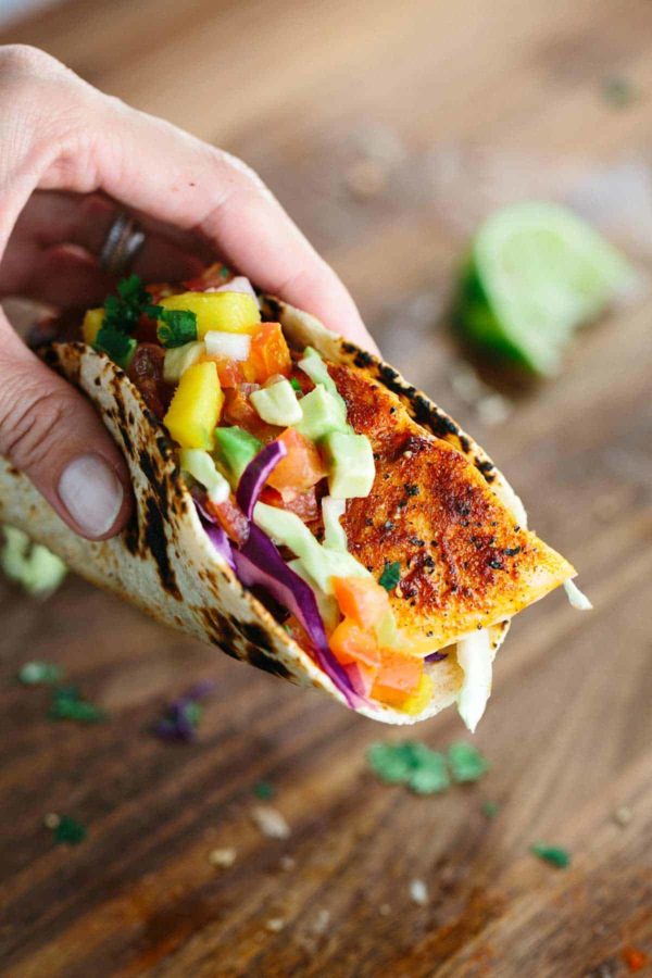 递拿着三文鱼炸玉米饼用水果辣调味汁