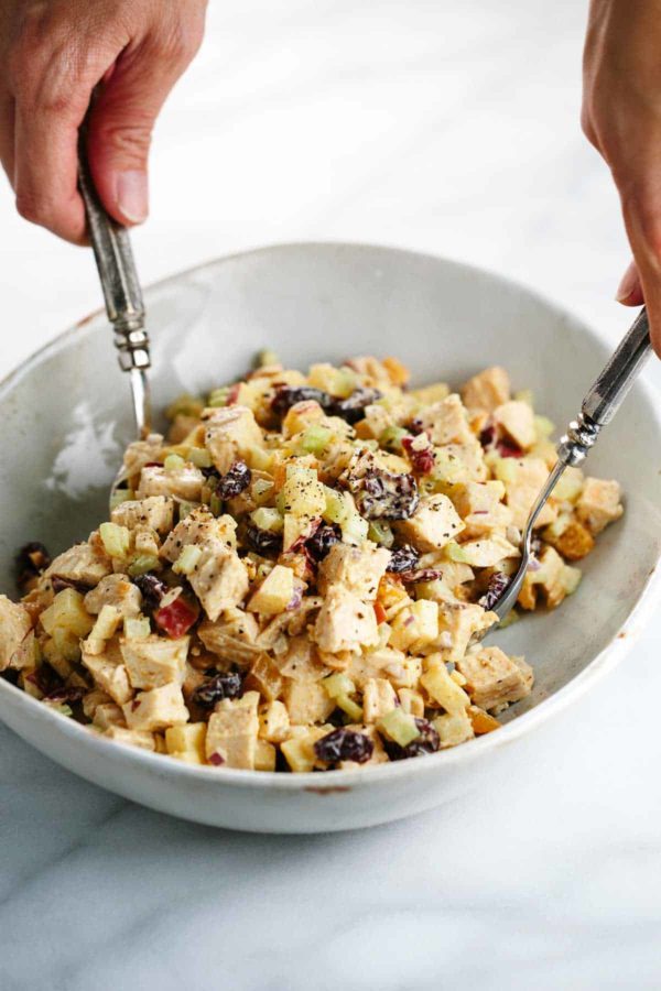 两只手拿着叉子,在一个碗里搅拌原料