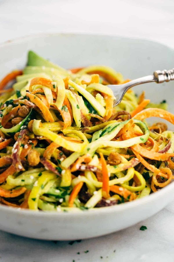 用叉子把蔬菜面条从沙拉碗里抽出来