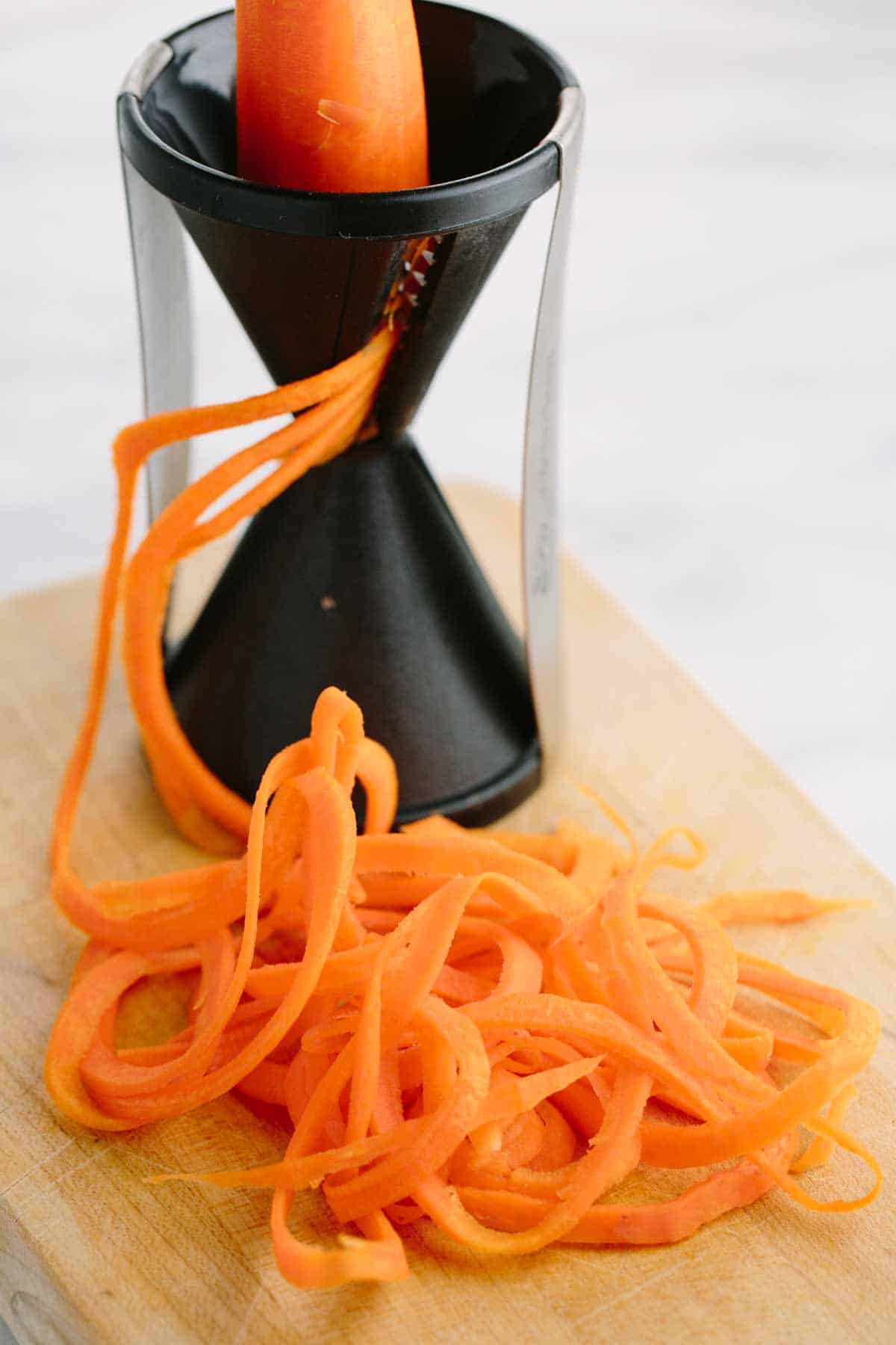 用螺旋剂在胡萝卜上做低碳水化合物蔬菜面条沙拉