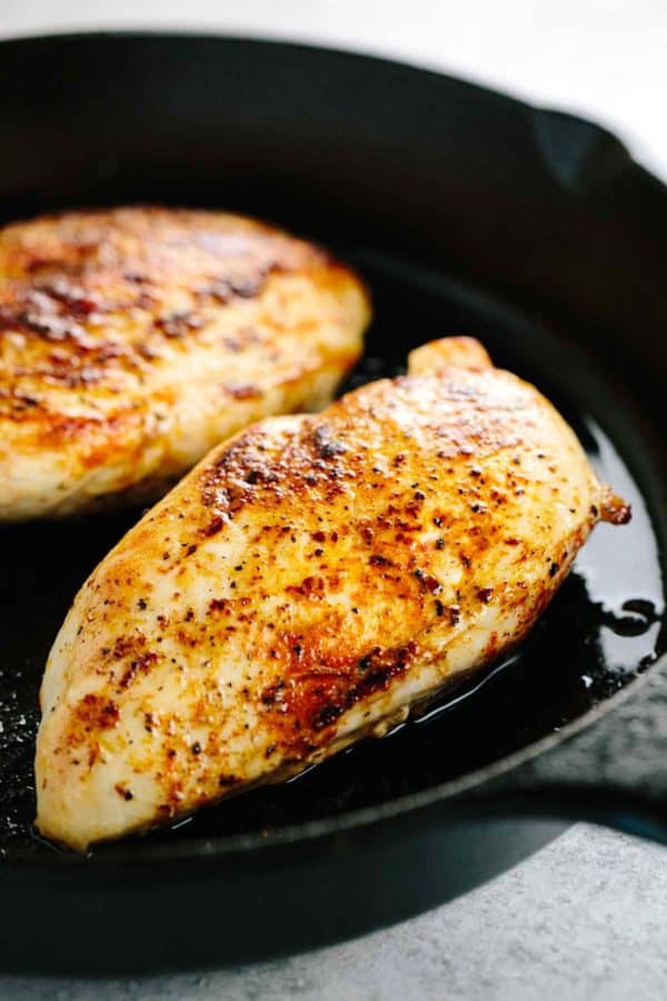 两块鸡胸肉在铁锅里煮