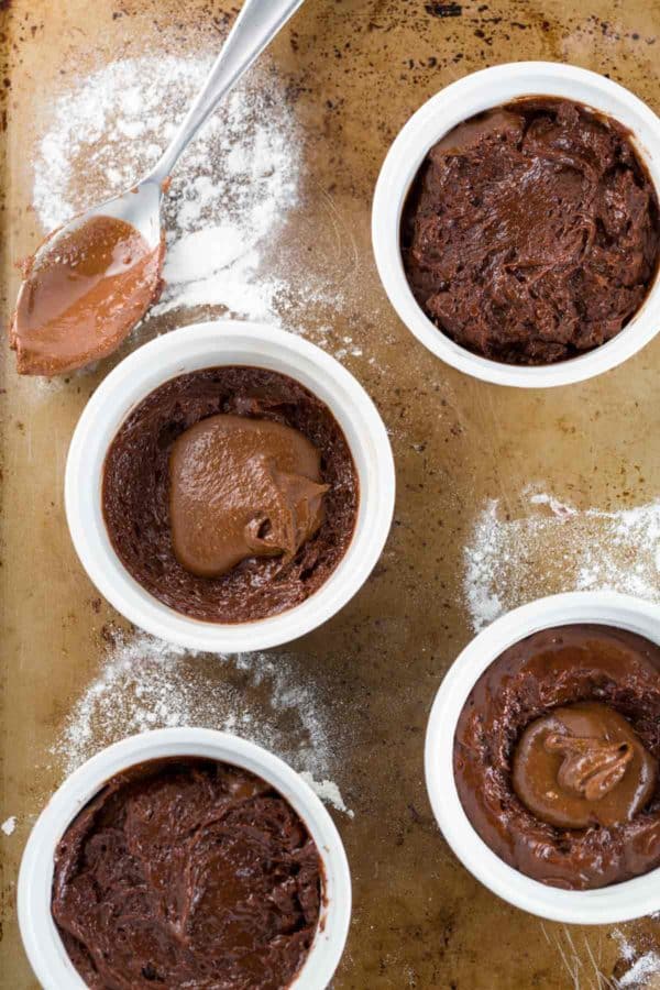 从上到下的巧克力酱被添加到四个熔岩蛋糕