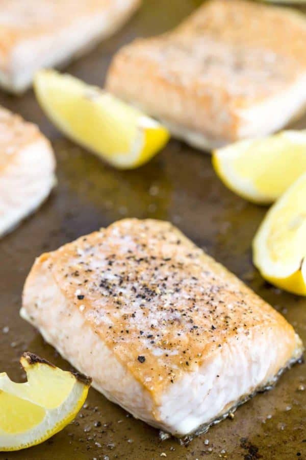 鲑鱼烘烤在纸板平底锅用柠檬楔子