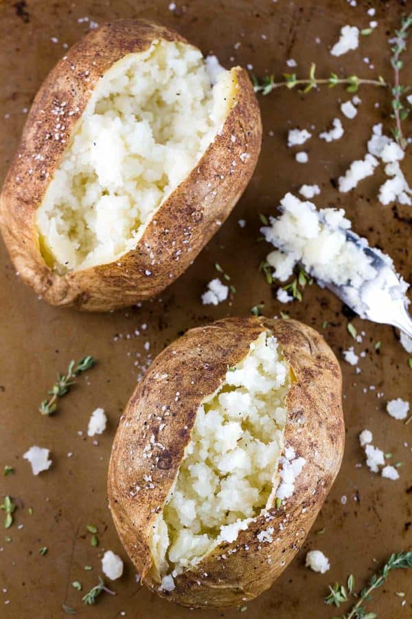 两个烤熟的土豆放在烤盘上