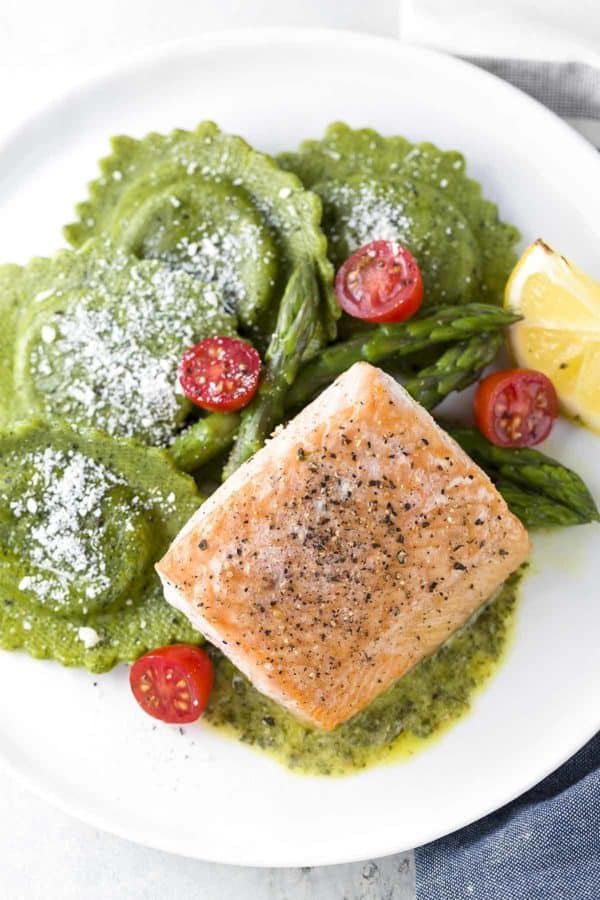 烤三文鱼用芦笋馄饨在餐盘上服务