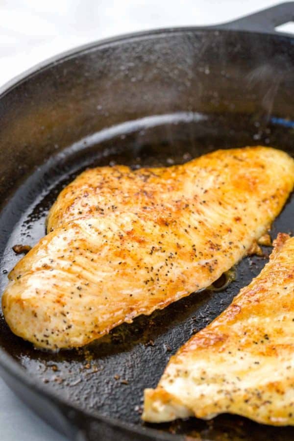 扁平的鸡胸肉在铸铁煎锅中烹煮