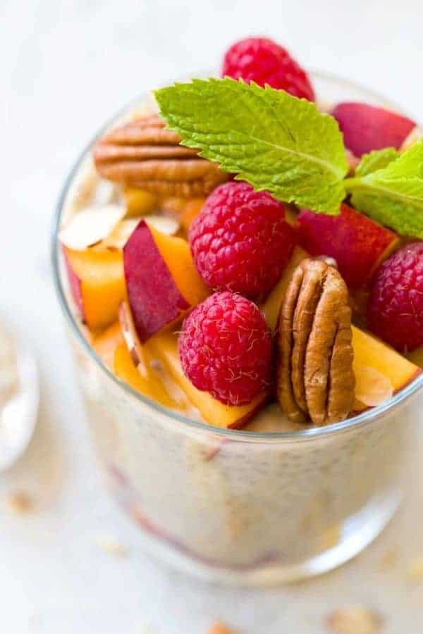 玻璃杯子克柴种子布丁用莓,切好的桃子和核桃在上面