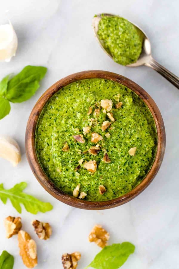 与被击碎的核桃的小木碗pesto调味汁在上面