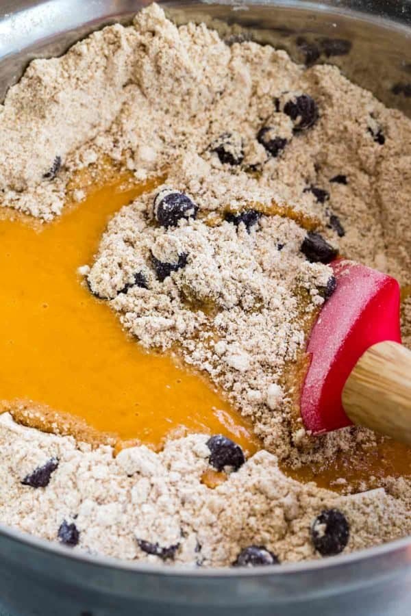 用红色的抹刀在碗里搅拌鸡蛋、黑巧克力片和面粉