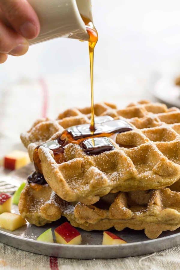 枫糖浆倒在一堆无谷蛋白苹果肉桂华夫饼上