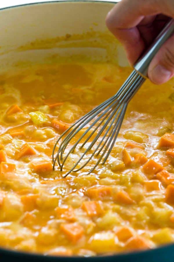 用小搅拌器搅拌一锅泰国椰子汤