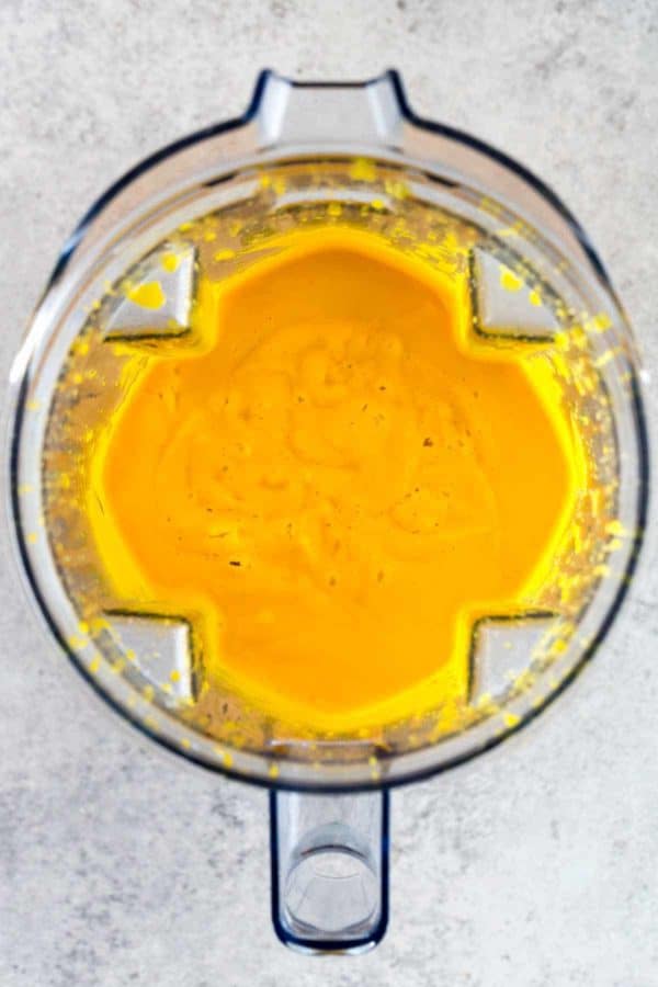 鲜亮的橙色甘薯泥在透明的搅拌机里