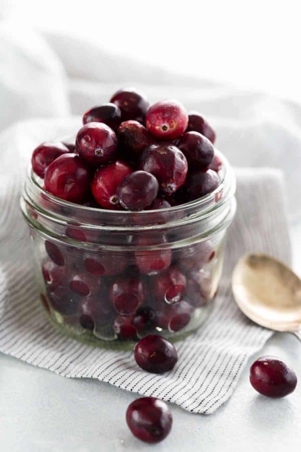 一个装满了小红莓的透明玻璃罐