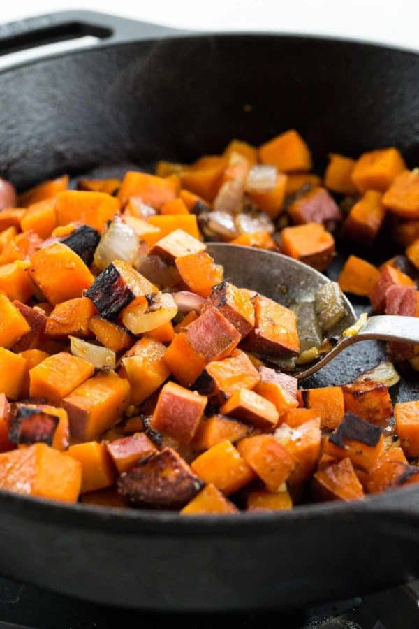 用金属勺在铁锅中搅拌红薯丁