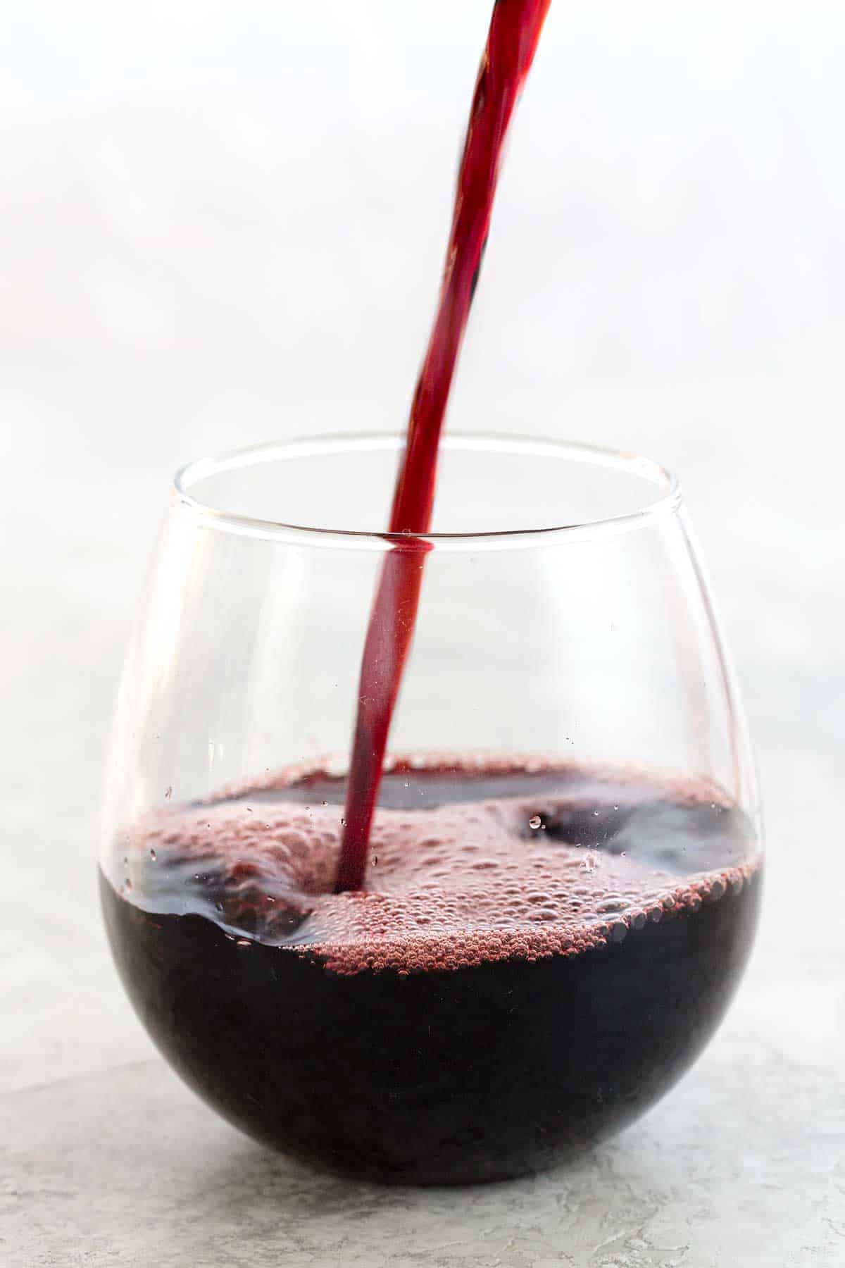 红葡萄酒倒入玻璃杯里