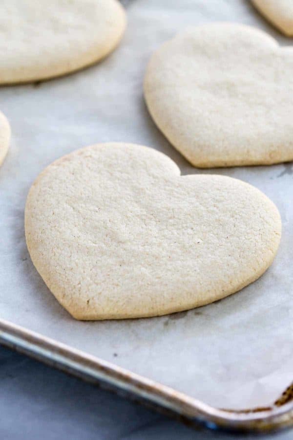 一个心形的饼干放在烤盘上,上面铺着羊皮纸