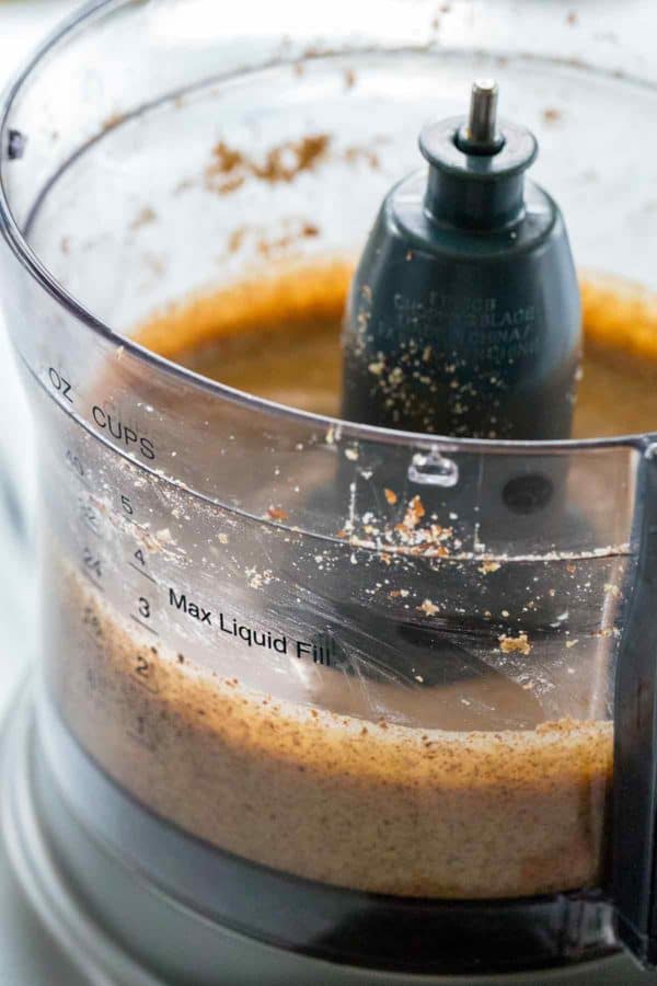 近距离照片显示坚果黄油正在制造的食品加工机