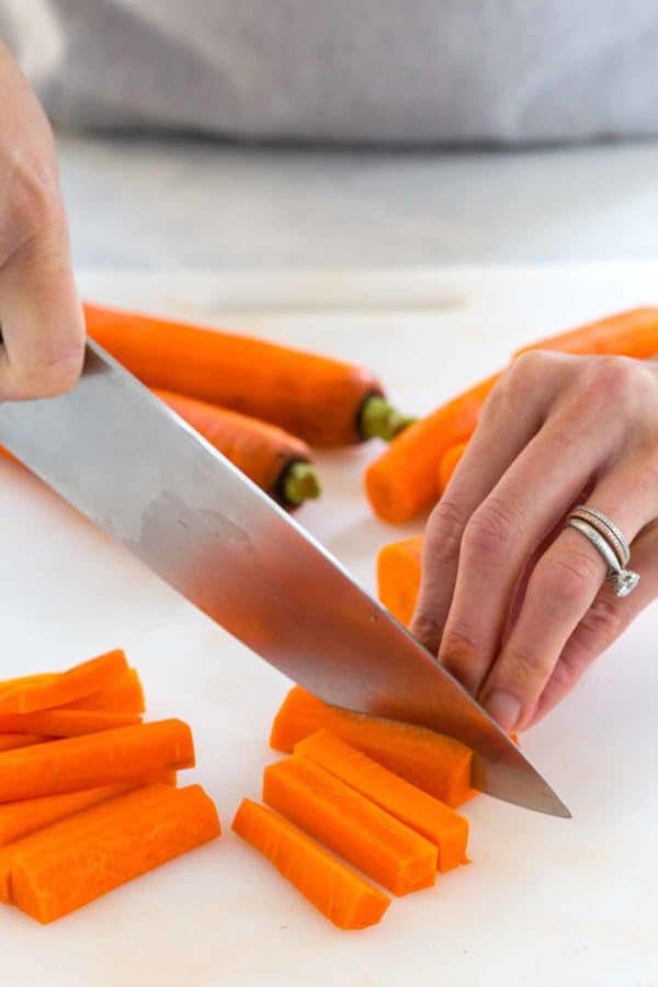 一张人用刀切胡萝卜的照片