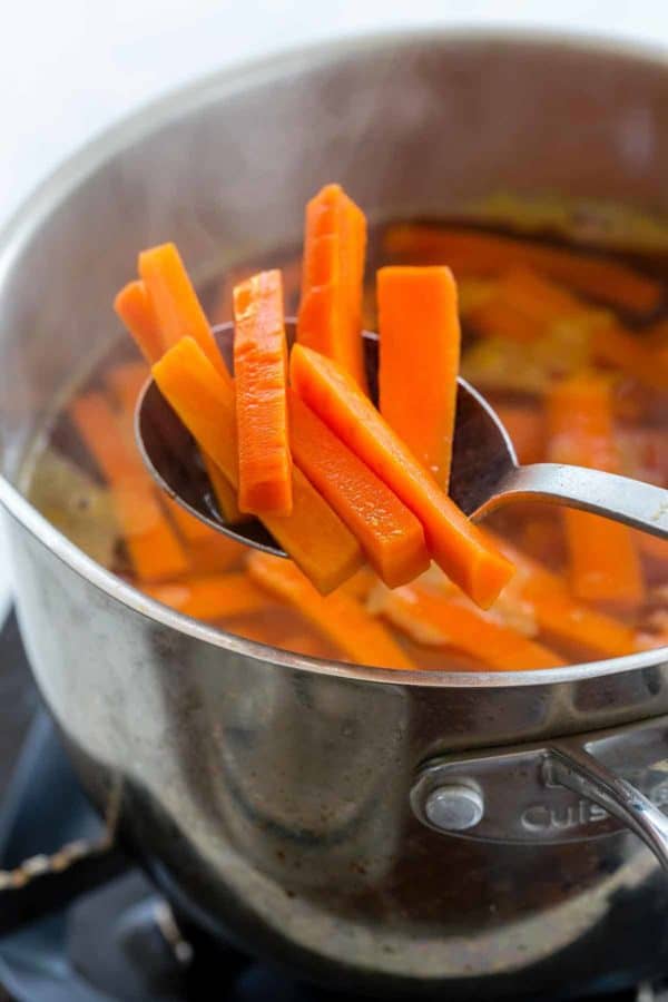 用勺子将切好的胡萝卜从沸水中取出