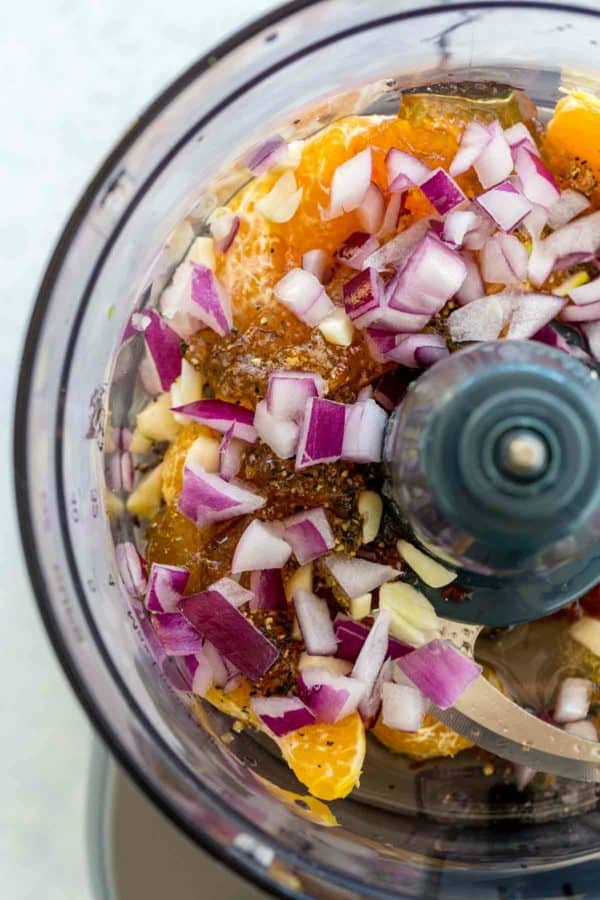 食品加工机装满切碎的洋葱和桔子