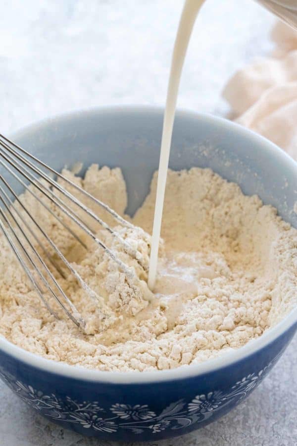 将腰果倒入一碗素食煎饼面糊