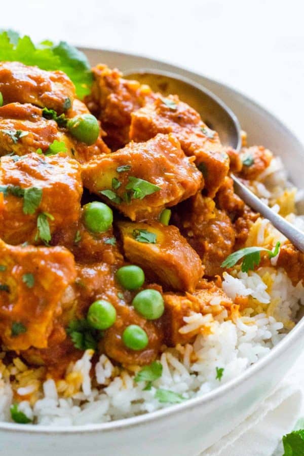 碗黄油鸡和白米冠上用豌豆