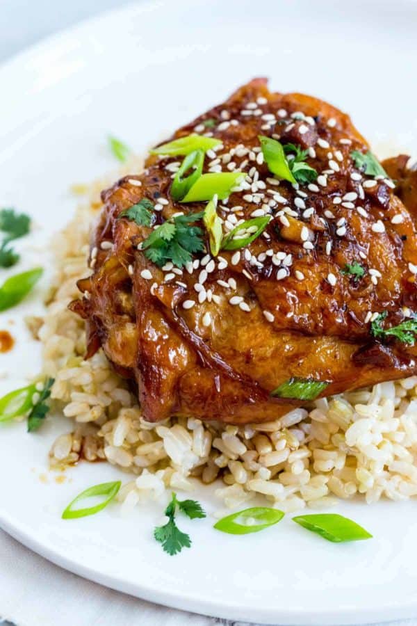 鸡大腿点缀着白色芝麻籽和葱在一块板材用白米