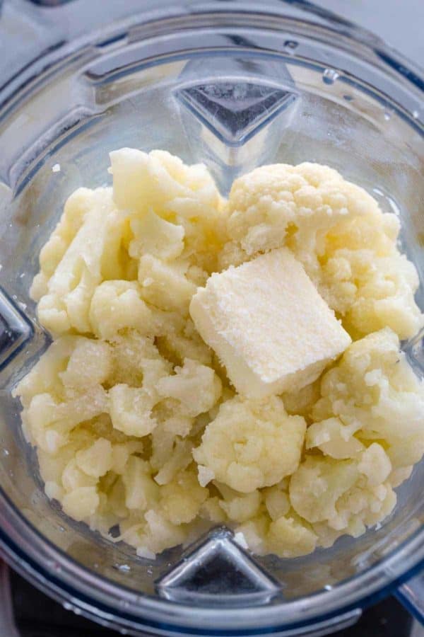 煮熟的花椰菜小花和一块黄油放在搅拌机里