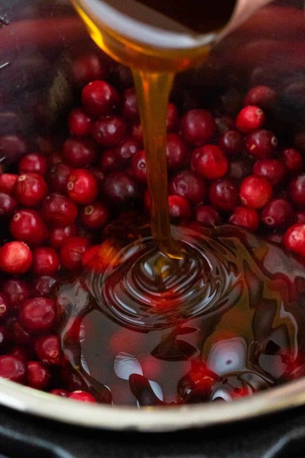 将蜂蜜倒入一个充满蔓越莓的瞬间锅中