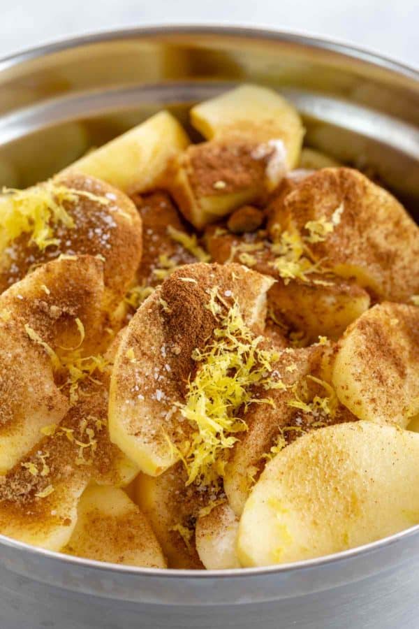 蜂蜜脆苹果片放在碗里,上面撒上肉桂香料和柠檬皮