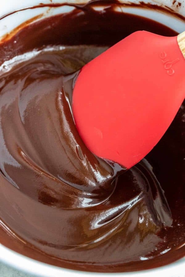 红色的抹刀在玻璃碗里搅拌融化的巧克力